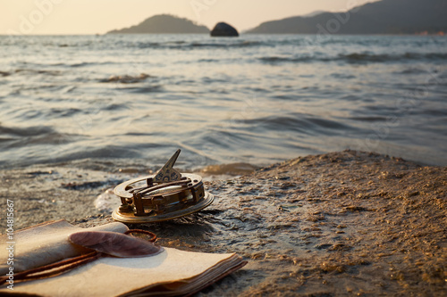 tropical rocky beach with old vintage sundial and note