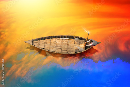 Man riding old style boat on the river in bangladesh photo