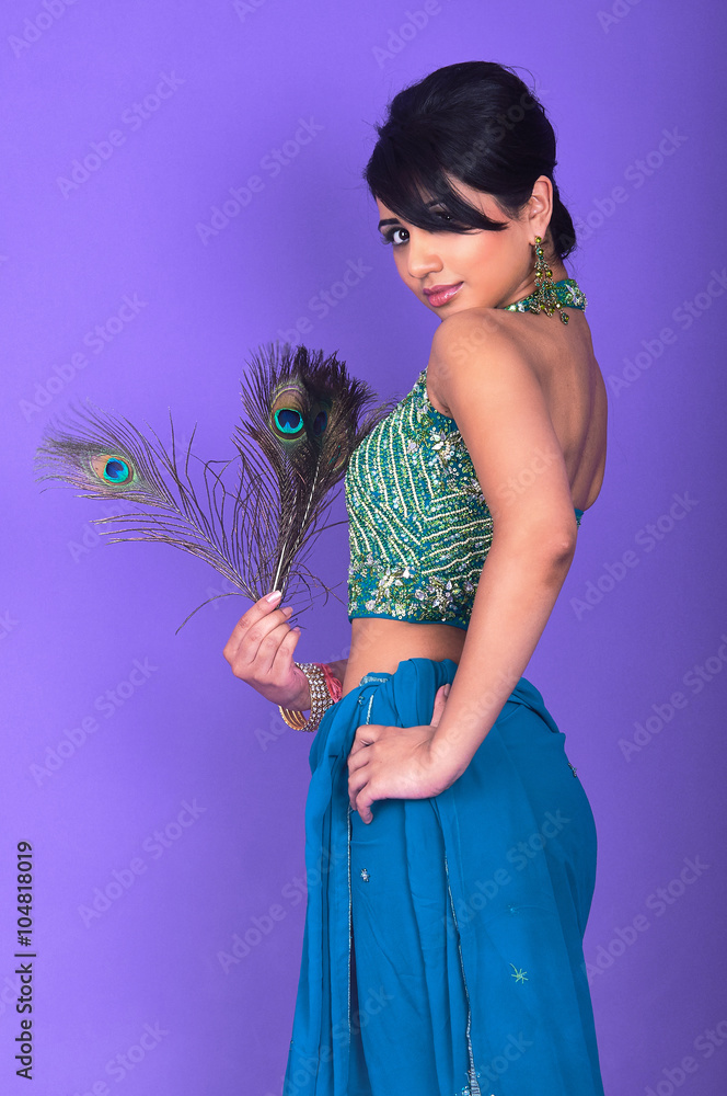 Asian model wearing indian dress and peacock feather on violet background at studio shoot Stock Photo Adobe Stock