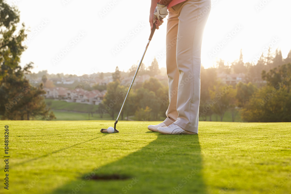 Fototapeta premium Close Up Of Male Golfer Lining Up Putt On Green
