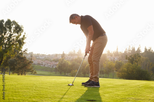 Quadro em tela Male Golfer Lining Up Putt On Green