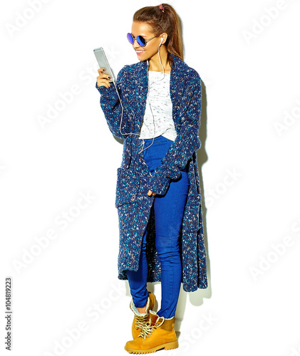 Full length beautiful happy cute smiling brunette woman girl in casual blue hipster summer clothes with no makeup isolated on white in sunglasses listening music in smartphone with headphones