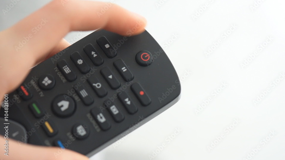 Human hand changes the channels on the TV remote control. Human hand changes the channels on the TV remote control.