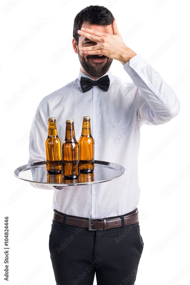 Waiter with beer bottles on the tray covering his face Waiter with beer bottles on the tray covering his face