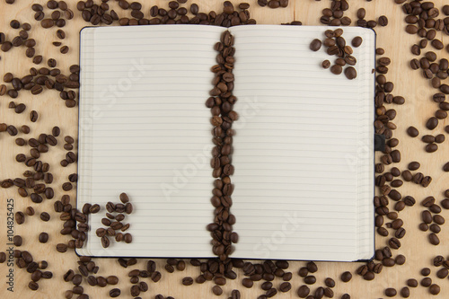 Open notebook with lined pages on a table on which are scattered