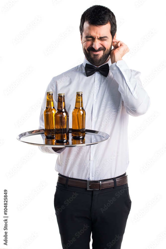 Waiter with beer bottles on the tray covering his ears Waiter with beer bottles on the tray covering his ears