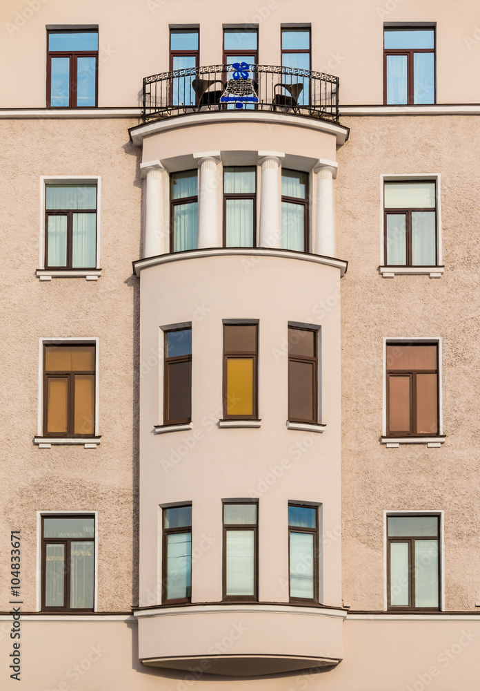 Many windows in row and bay window on facade of urban apartment building front view, St. Petersburg, Russia.