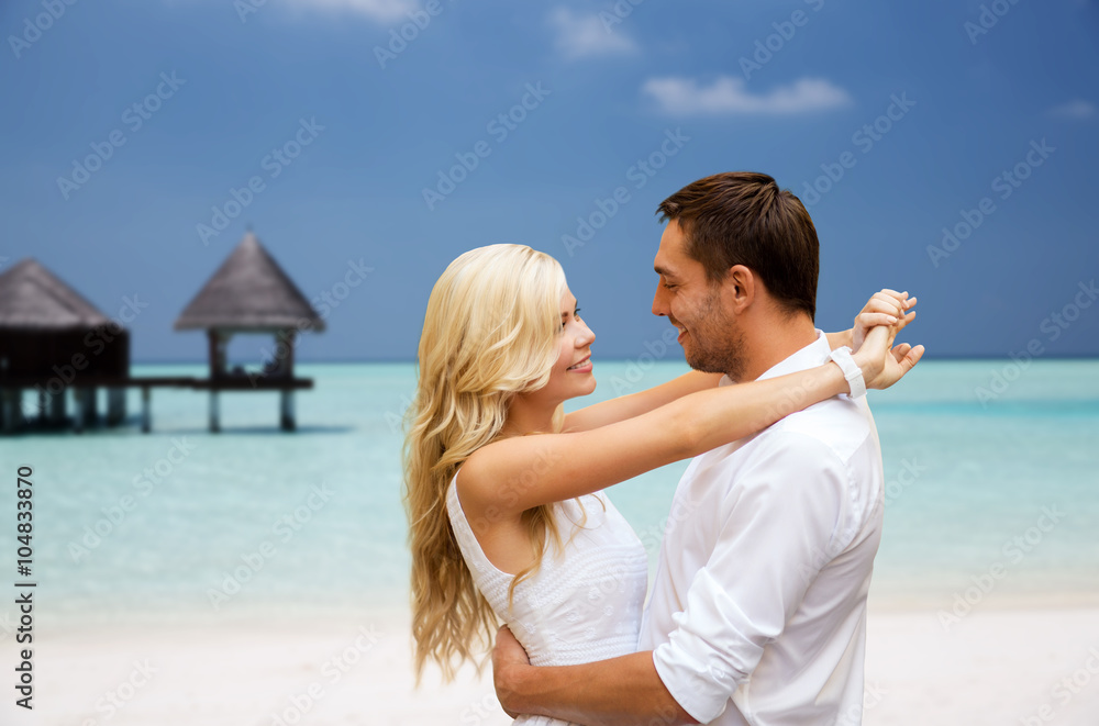 happy couple having fun over beach with bungalow happy couple having fun over beach with bungalow