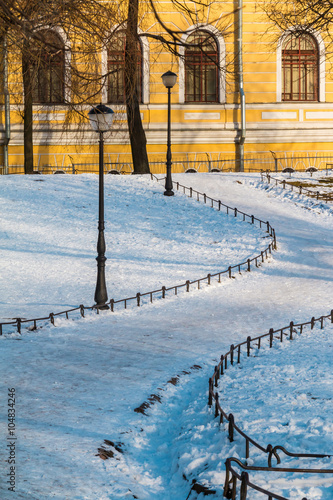 Footpah in Yusupov garden and facade of Petersburg State Transport University's building in winter scene.