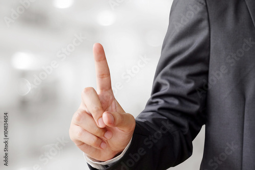 Hand point gesture on blur office background photo