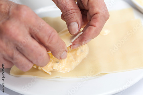Doblando los triángulos rellenos para la lasagna parmesana