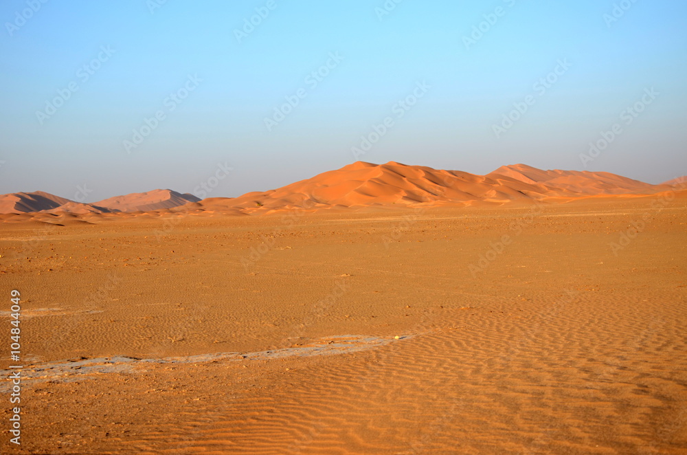 Sand dune hill on empty plane in desert Oman