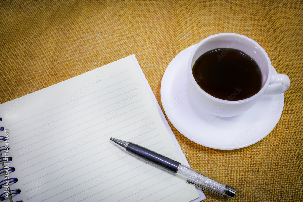 coffee in white cup with notebook for memory. coffee in white cup with notebook for memory.