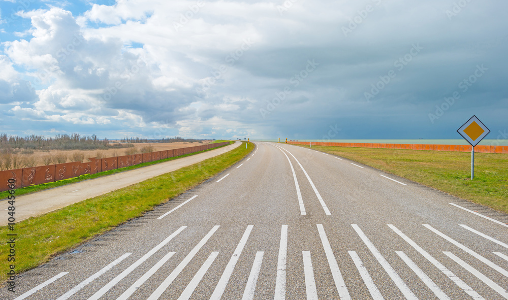 Fototapeta premium Road over a dike along a lake in winter