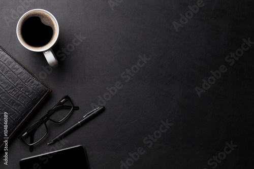 Office leather desk table with coffee and supplies photo