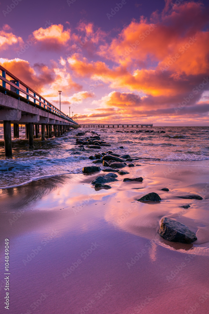 Obraz premium Pier and sea at pink sunset