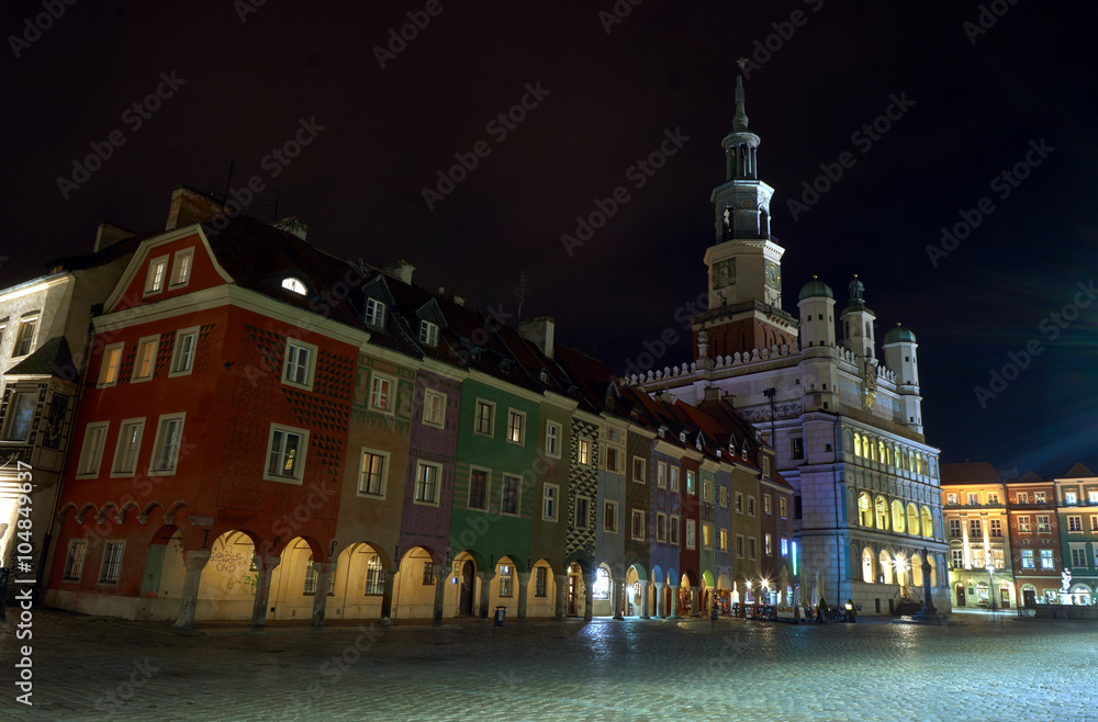 Buildings and Renaissance town hall at night in Poznan, Poland .