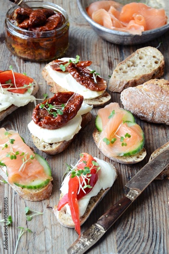 Appetizers. Toasts with salmon, dried tomatoes and sweet peppers