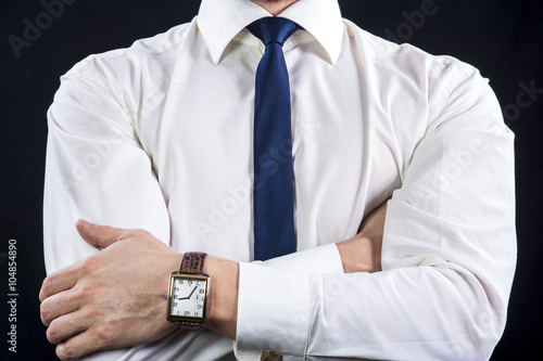 Elegant businessman in white shirt and necktie crossing his arms on chest.