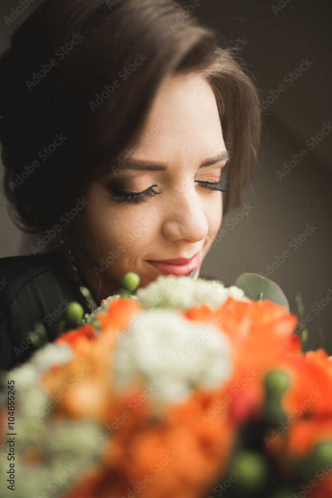 Fototapeta premium Luxury bride in black robe posing while preparing for the wedding ceremony