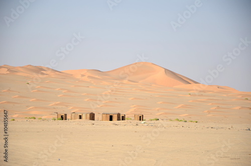 Small huts in sand dunes in desert  Oman