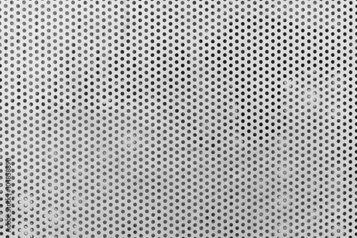 Background sheet of metal covered with lines of circular holes