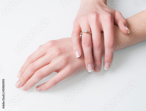 Woman hands with engagement ring on white