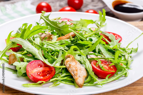 low-calories salad with chicken breast, arugula and cherry tomat