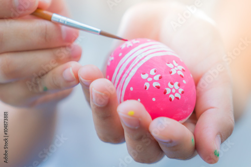 Woman hand decorating Easter eggs
