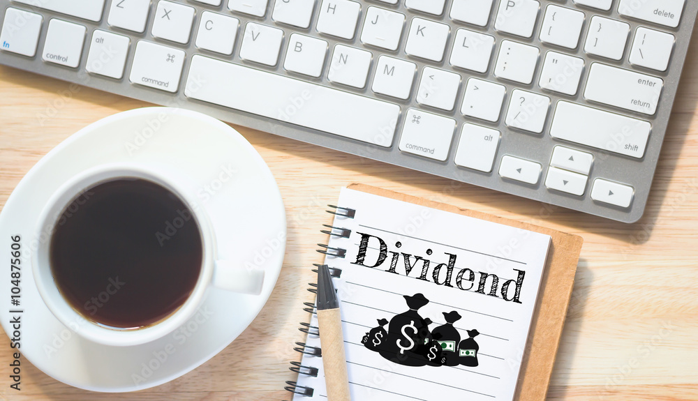 Concept dividend message on book. A pencil and a glass coffee table.Vintage tone. Concept dividend message on book. A pencil and a glass coffee table.Vintage tone.