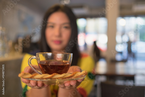 hot tea and blurry woman / Woman in colorful dress is drinking and sipping hot tea in coffee shop, blurry