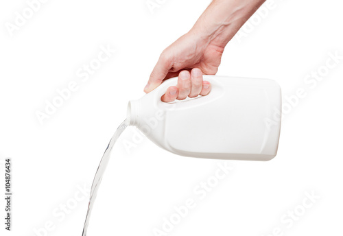 Flows out  liquid from white plastic bottle in hand, isolated on