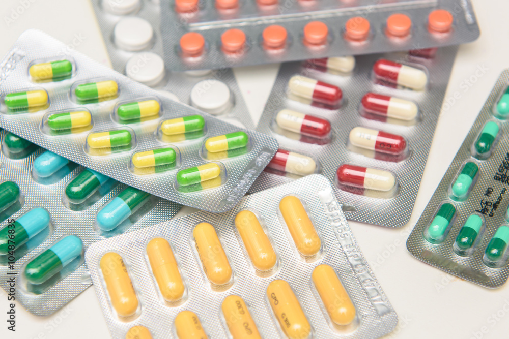 colorful capsules and pills closeup on white colorful capsules and pills closeup on white