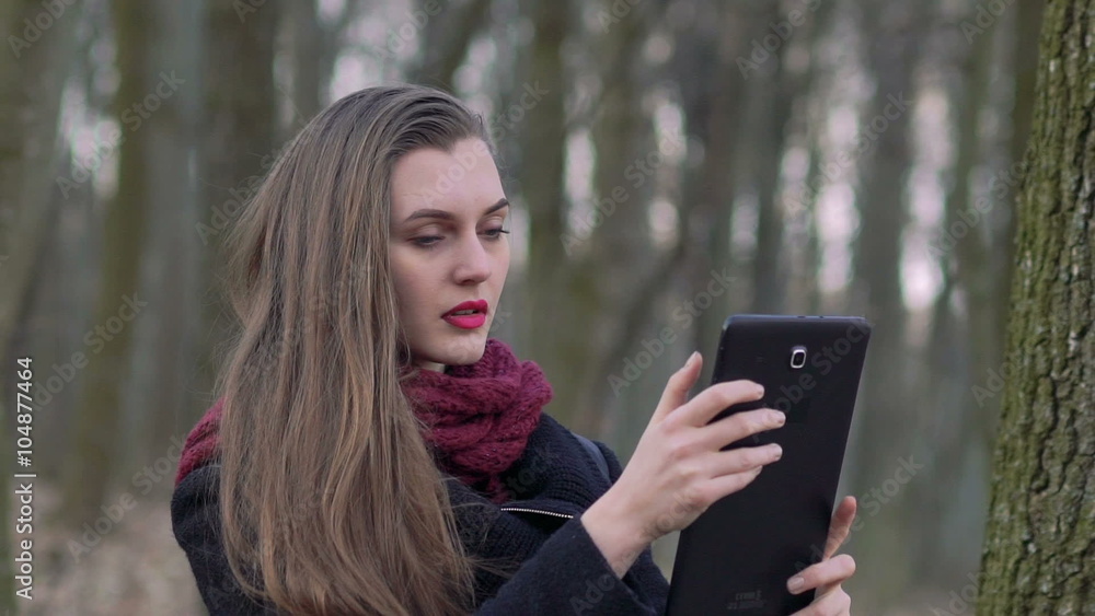 Portrait of a girl with a tablet in the forest. Slowly Portrait of a girl with a tablet in the forest. Slowly