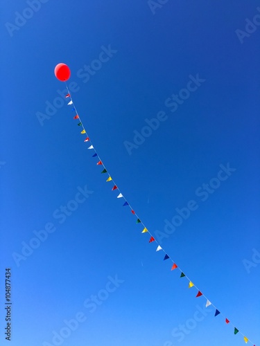 Helium filled balloon on a long rope with flags. 