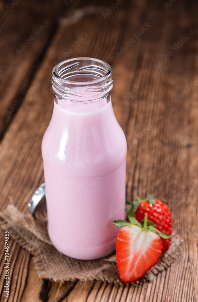 Milk (Strawberry flavoured) on wooden background Milk (Strawberry flavoured) on wooden background