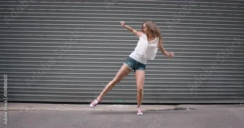 Contemporary funky caucasian woman street dancer dancing freestyle in the city