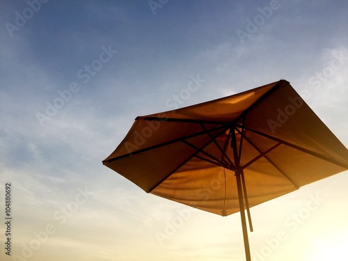 beach umbrella setting sun