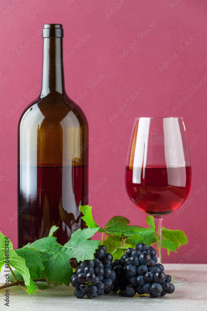 Wine bottle and wineglass with grapes