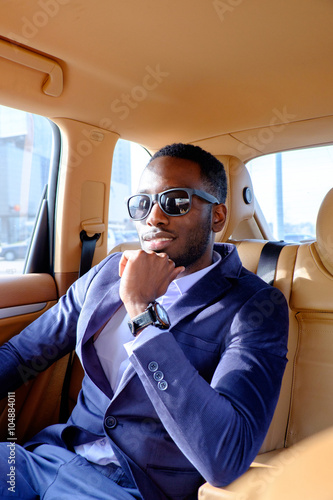 Blackman in a suit in the car. © Fxquadro