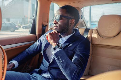 Blackman in a suit in the car. photo