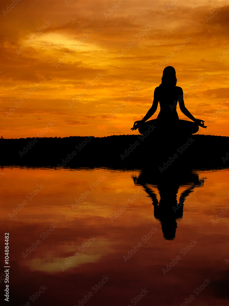 Silhouette of a beautiful Yoga woman with water reflection