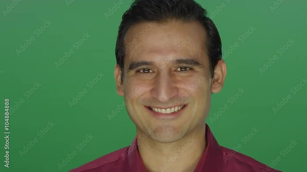 Ethnic man nodding and smiling, on a green screen studio background Ethnic man nodding and smiling, on a green screen studio background