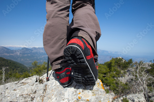  Hiker standing on top of the mountain with valley on the background.