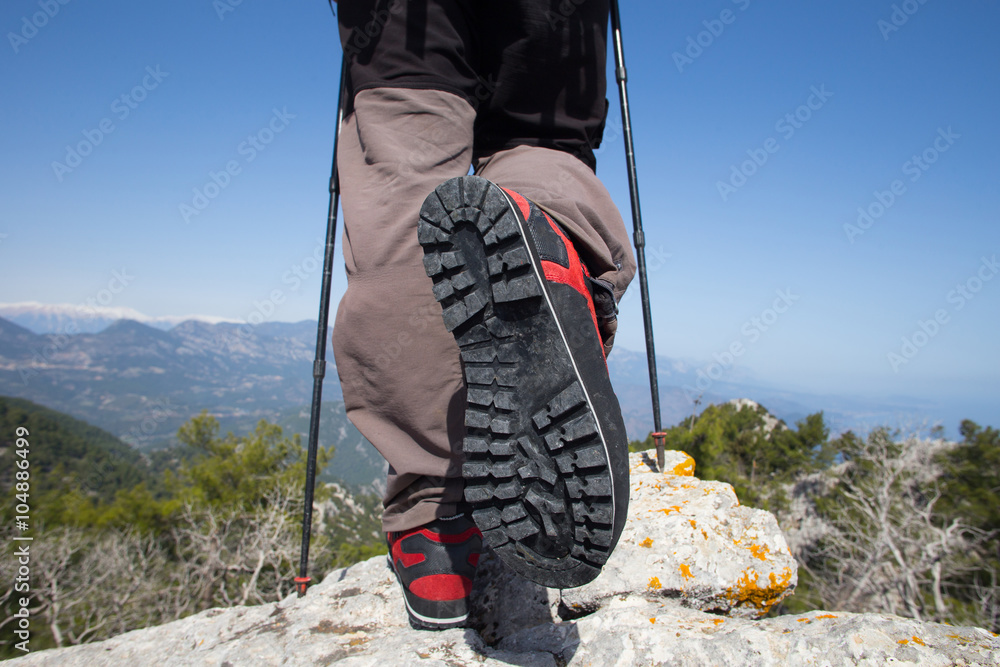 Hiker standing on top of the mountain with valley on the background. Hiker standing on top of the mountain with valley on the background.