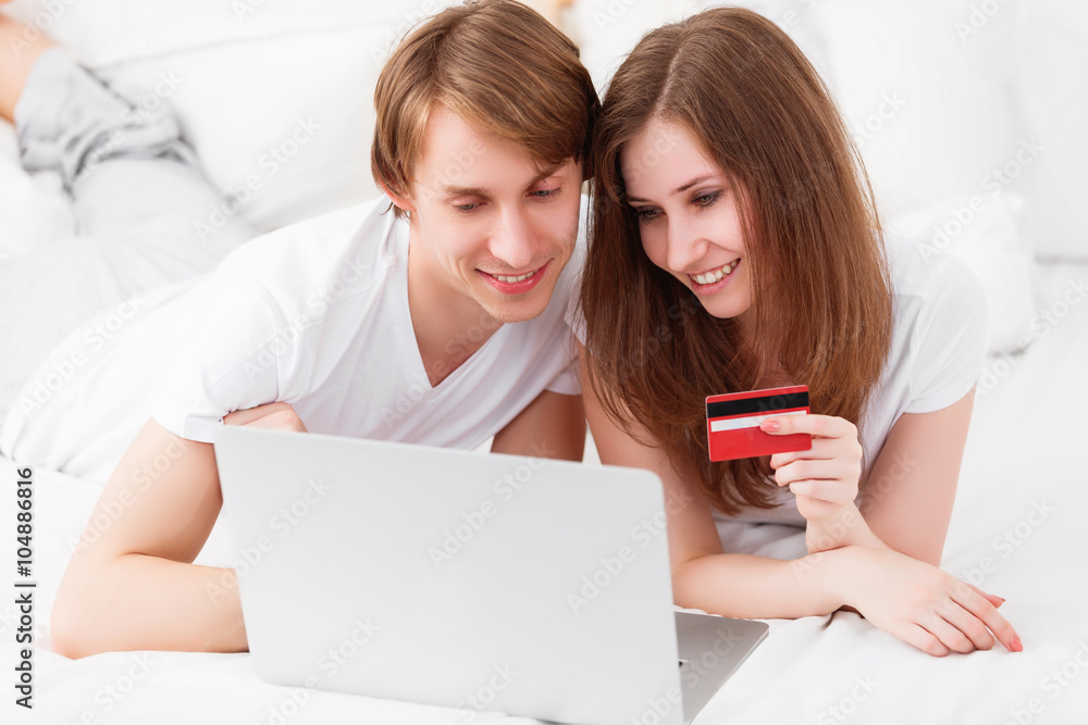 happy couple makes online shopping with laptop and credit card a happy couple makes online shopping with laptop and credit card a
