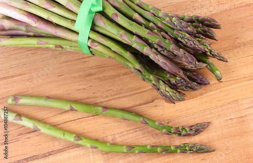 Green asparagus on wooden surface, healthy eating