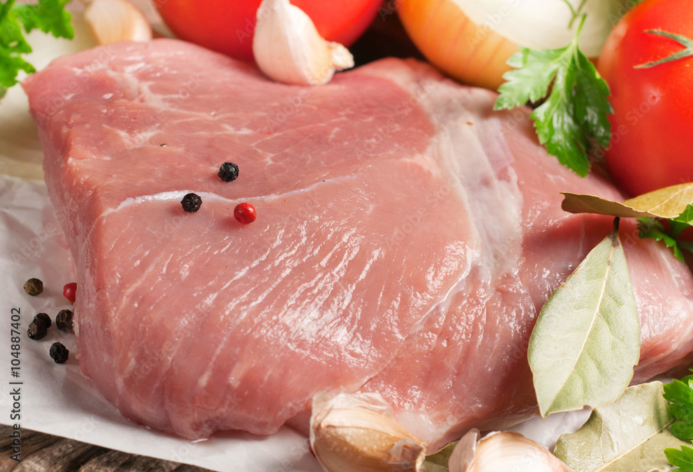 Closeup fresh raw meat tenderloin with vegetables Closeup fresh raw meat tenderloin with vegetables