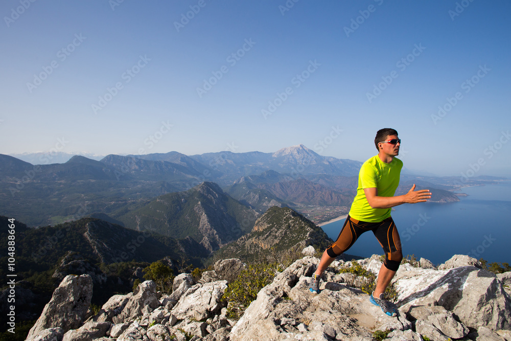 Fototapeta premium Man practicing trail running with a coastal landscape in the background.