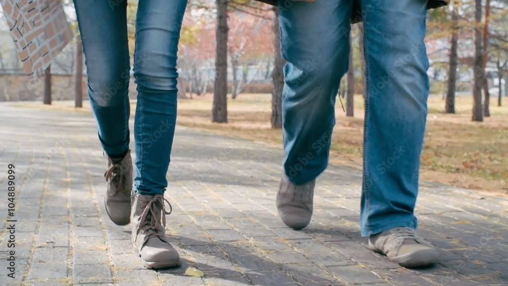 Close up of legs of man and woman walking towards the camera in the park Close up of legs of man and woman walking towards the camera in the park